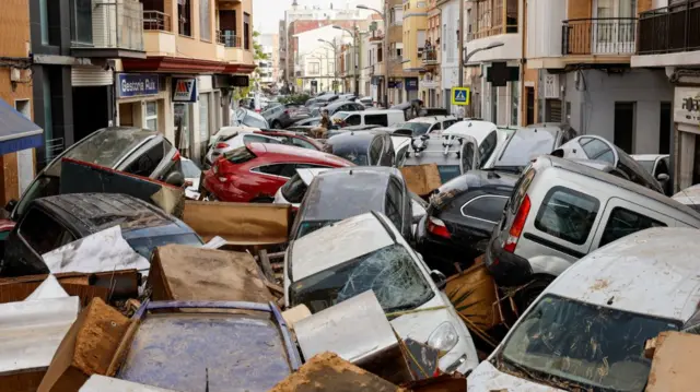 Piles of cars fill up street in Valencia region after heavy flooding