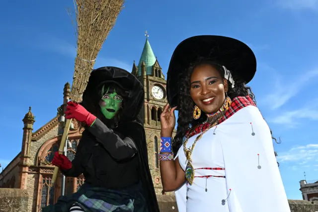 derry mayor dressed as a witch outside guidlhall at halloween. she is pictured along with another woman in withc costume