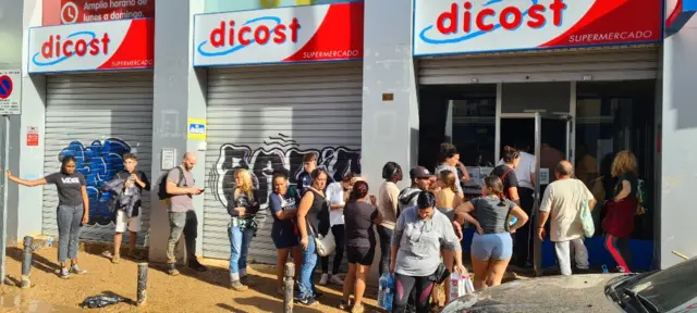 Queue of people outside supermarket