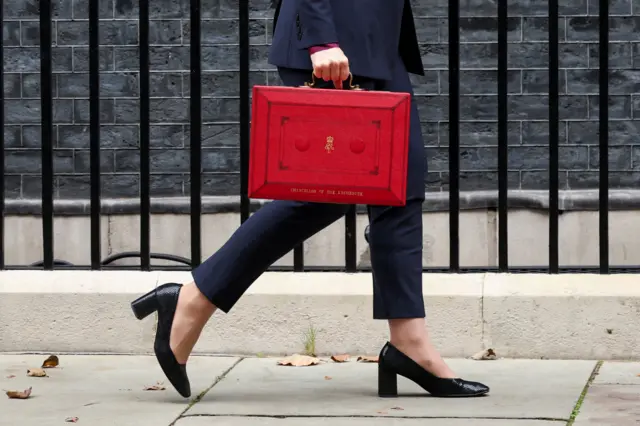 Britain's Chancellor of the Exchequer Rachel Reeves walks with the red budget box outside her office on Downing Street in London