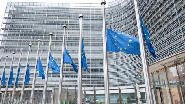 The blue European flags in front of the EC  headquarters in Brussels are at half-mast