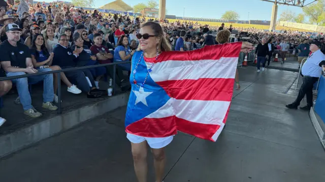 A woman walks wearing a top designed to resemble the Puerto Rico flag