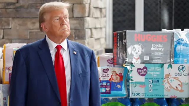 Donald Trump stands with products to be given to Hurricane Helene victims