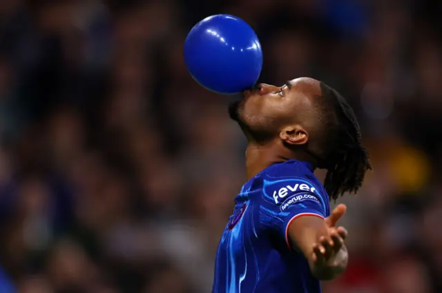 Christopher Nkunku blows a balloon to celebrate scoring against Gent