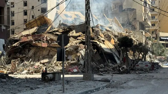 A pile of rubble from a collapsed building on a street corner in Beirut