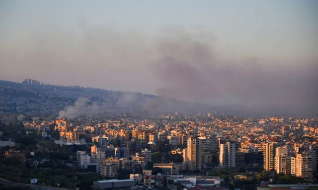 Smoke billowing up out of the city in multiple places across a cityscape of Beirut