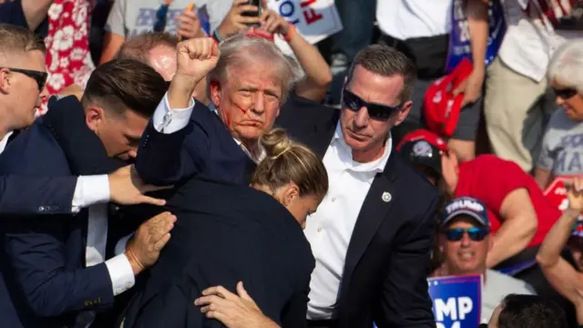 Donald Trump raises his fist after assassination attempt