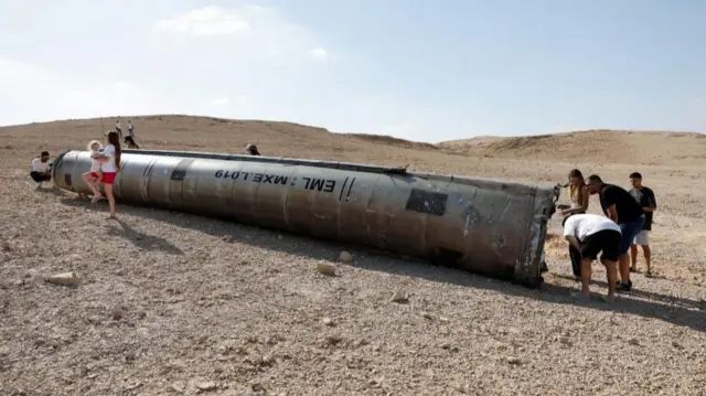 People inspecting the remains of a missile in Israel