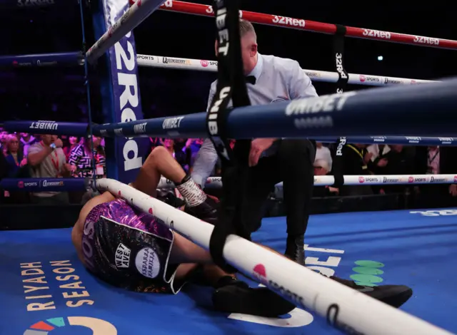 Ronny Rios falls through the ropes in the ring