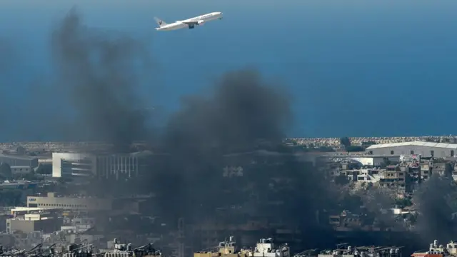 Plane flying as smoke rises over Beirut