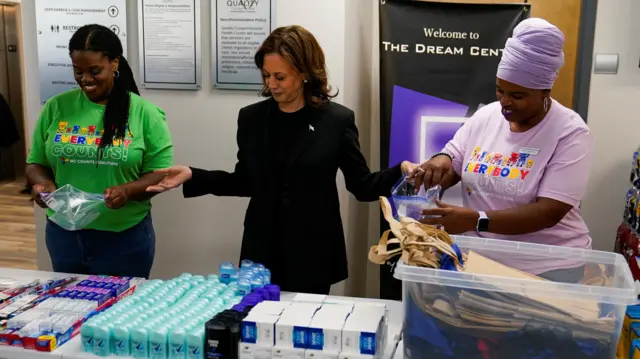 Kamala Harris, wearing a black suit, prepares care packages with volunteers in North Carolina