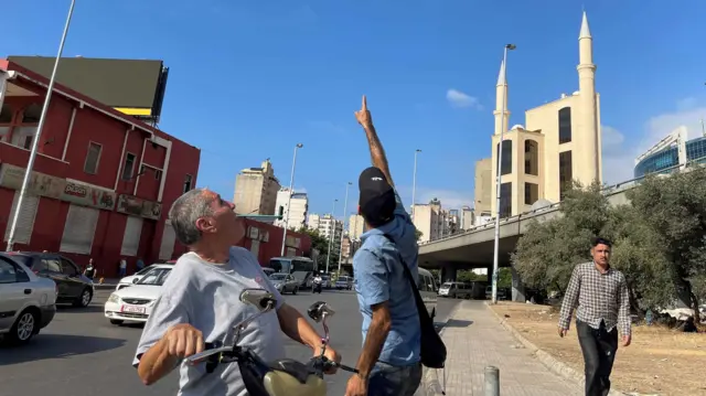 People pointing at Israeli drones in Beirut