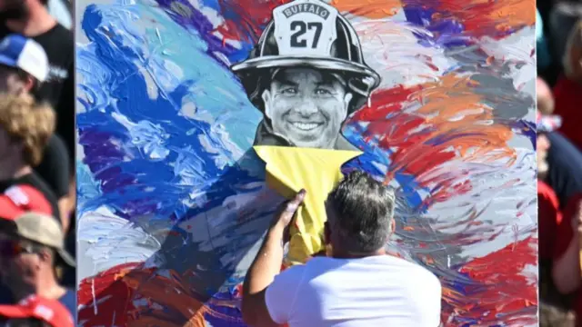 Artist Scott LoBaido unveils a portrait of fireghter Corey Comperatore, who was killed in an assassination attempt on former US president and Republican presidential candidate Donald Trump, ahead of his rally in Butler, Pennsylvania, on October 5, 2024