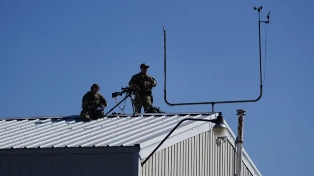 Two snipers stands on the roof of a building near the site of a Trump rally in Butler, Pennsylvania