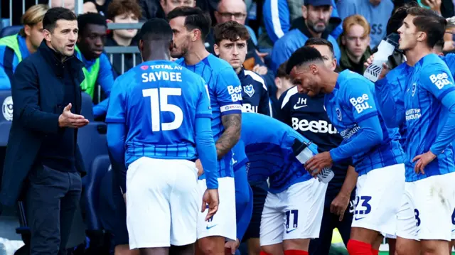 Portsmouth manager John Mousinho speaks to his players during the Oxford game