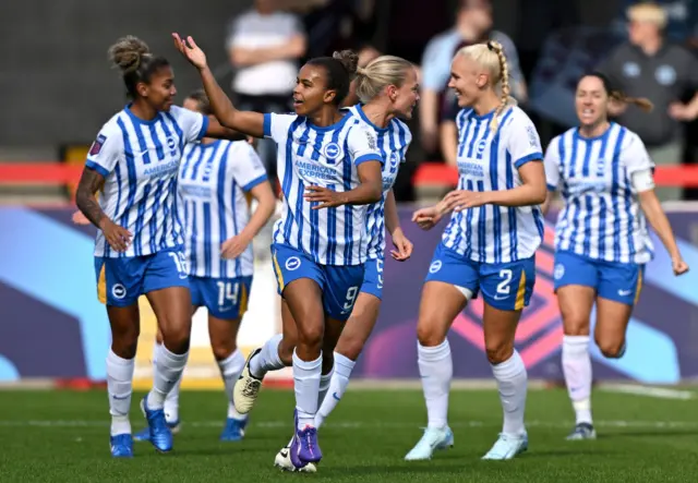 Parris celebrates with teammates after scoring the Brighton equaliser