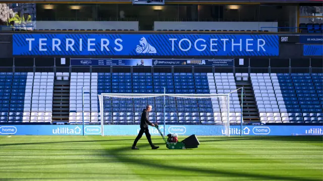 Huddersfield Town groundstaff mowing the pitch