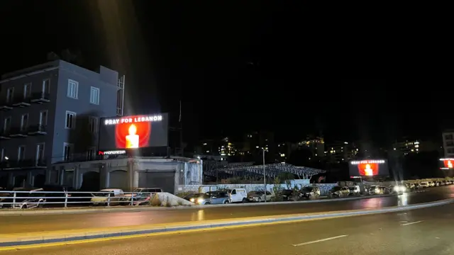 A billboard reading "Pray for Lebanon"