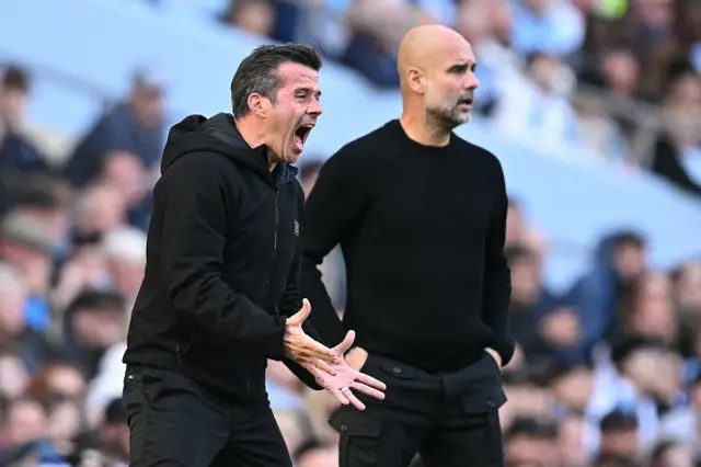 Marco Silva (L) and Manchester City's Spanish manager Pep Guardiola (R) look on