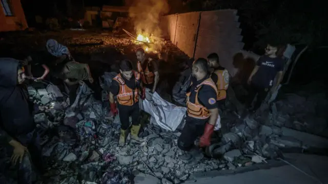 People clear debris of building hit by Israeli air strike