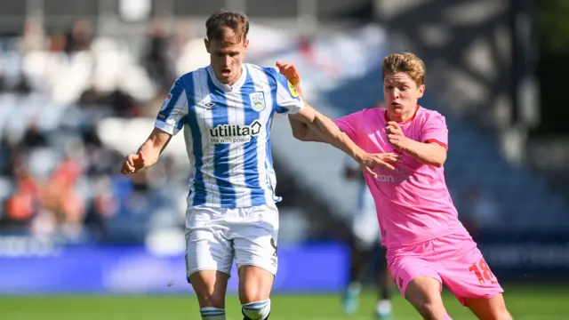 Huddersfield's Bojan Radulovic fends off Matthew Craig of Barnsley