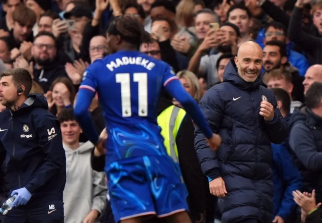 Noni Madueke celebrates with manager Enzo Maresca