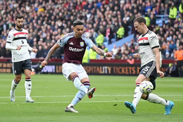 Morgan Rogers of Aston Villa is challenged by Jonny Evans