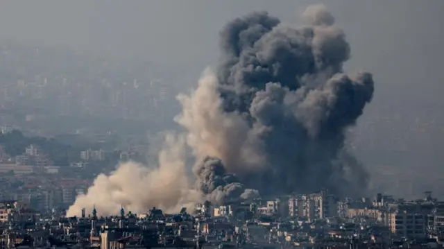 A large cloud of smoke can be seen rising above the city skyline