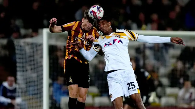 Newport County striker Kyle Hudlin competes for a header with Bradford defender Neill Byrne