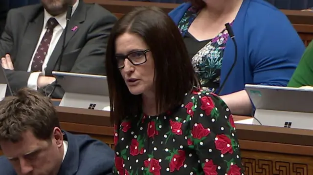 Paula Bradshaw wearing a black dress with white spots and red flowers