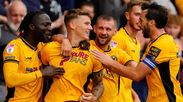 Newport County's players celebrate scoring a goal