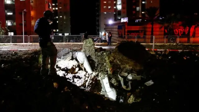 An Israeli rescue force member inspects the site where a projectile fell,amid cross-border hostilities between Hezbollah and Israel, in Haifa, northern Israel October 7, 202