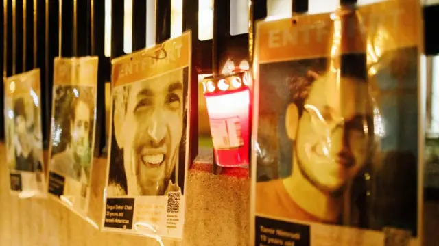 Portraits of Israeli hostages hang at a fence in front of the Synagogue at the Fraenkelufer in Berlin, Germany