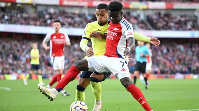 Arsenal's Bukayo Saka being challenged by Cameron Archer of Southampton