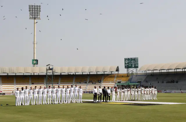 Players line up for the national anthems before the match