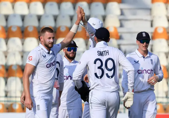 England's Gus Atkinson celebrates with teammates after taking the wicket of Pakistan's Abdullah Shafique