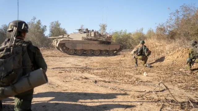 Three soldiers and a tank readying for battle