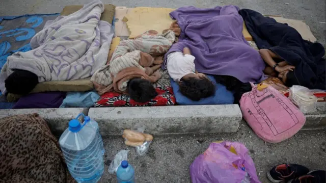 Displaced children sleep at a parking lot in the centre of Beirut