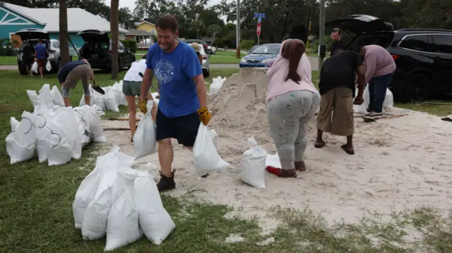 People in Florida filling and moving bags of sand to protect them against Hurricane Milton