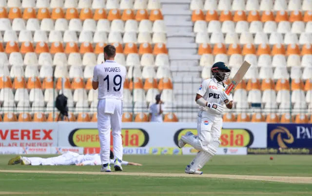 Pakistan's Saud Shakeel in action as he runs between the wickets as England's Chris Woakes looks on