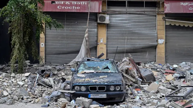 A damaged car under the rubble of a building following an Israeli airstrike on the Dahieh district in Beirut