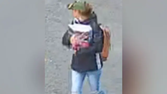 A CCTV image of Victoria Taylor, wearing a hat and backpack, clutching a bag