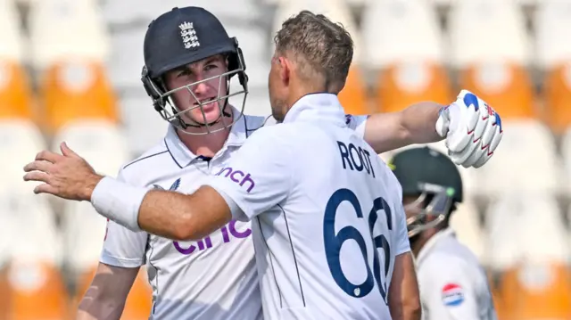 Joe Root celebrates with Harry Brook after scoring a century during the third day of the first Test match between Pakistan and England