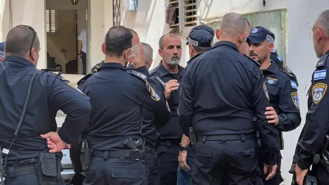 Israel Police Commissioner Daniel Levy speaks to a large group of officers at the scene in Hadera