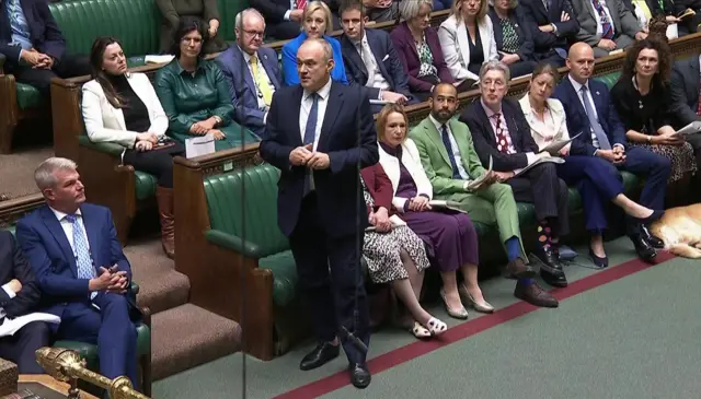 Ed Davey standing in front of Commons green benches as he asks question to Starmer