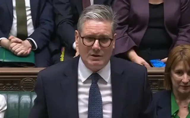 Close up of Keir Starmer in Commons wearing dark blue suit, white shirt and patterned dark blue tie