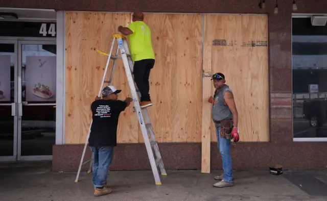 Workers board up a business ahead of Hurricane Milton's expected landfall in St. Petersburg, Florida, US,