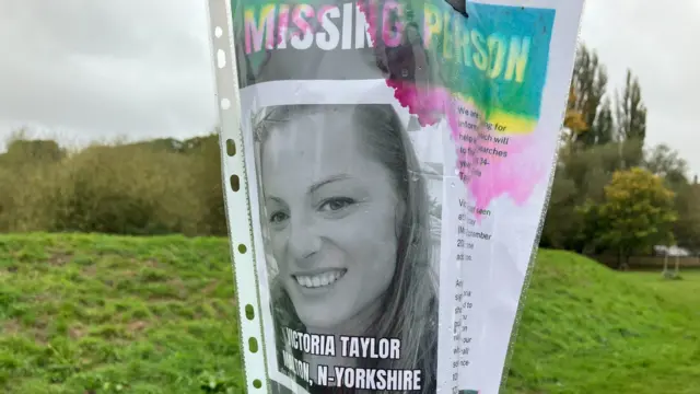 Home-made sign attached to a lamppost with a picture of Victoria Taylor on it