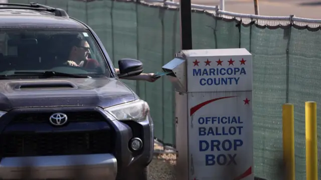 A voter casts his ballot at a drop box