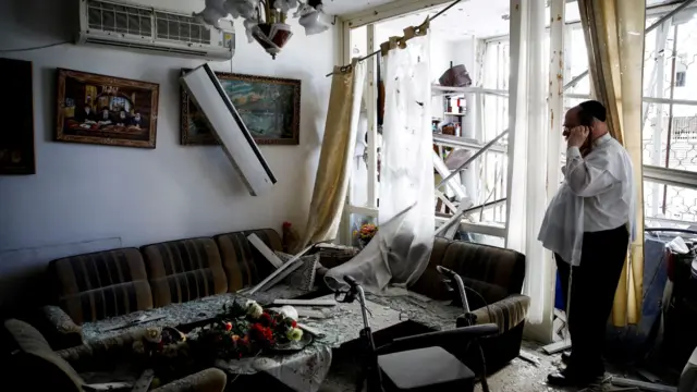 A man stands inside a residential apartment building that was damaged by a rocket fired from Lebanon, amid hostilities between Hezbollah and Israel, in Kiryat Yam, northern Israel,